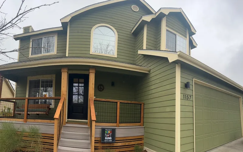 Green exterior house painting with cedar accents and porch in Fort Collins