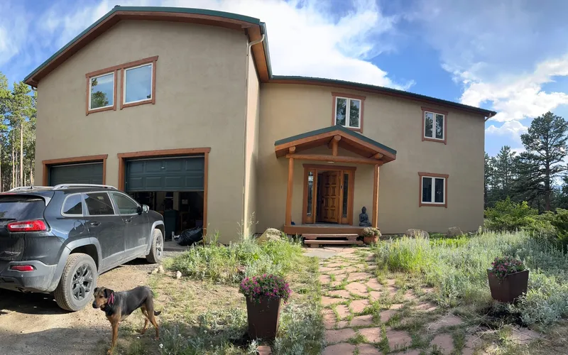 Two-story stucco mountain home in warm earth tones with wood trim